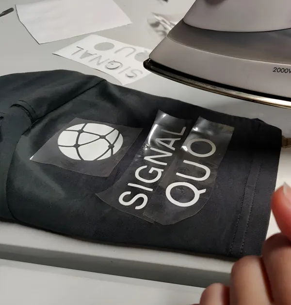 Signal Quo's logo being applied to a shirt